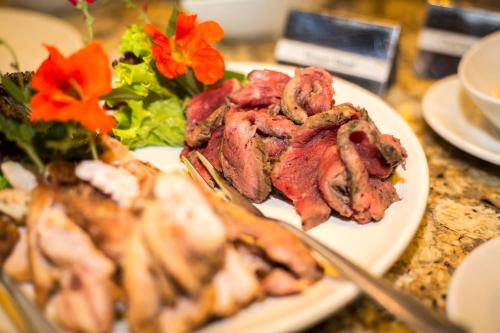 a plate of food with meat and a salad on a table at Victoria Falls Safari Club in Victoria Falls
