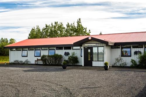 a white building with a red roof at South Central Country-Apartment in Brautarholt