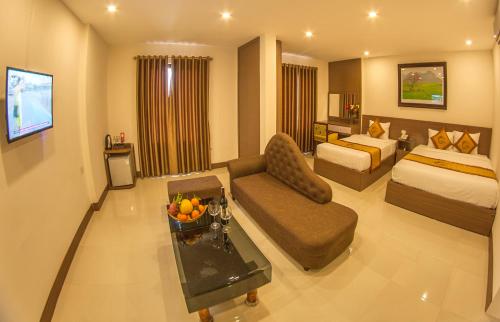 a large hotel room with a bed and a couch at La Paloma Hotel Ninh Binh in Ninh Binh