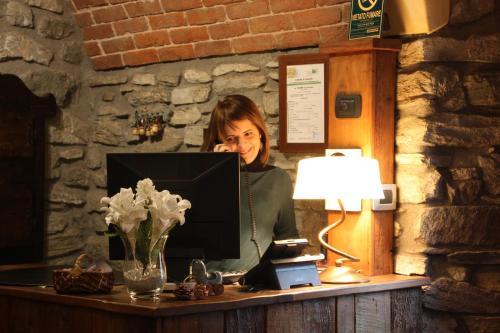 a woman sitting at a desk with a computer at Lo Teisson in Aosta