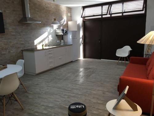 カステリョ・デンプリエスにあるLoft Costa Brava-Castellò D'Empúriesのリビングルーム(赤いソファ付)、キッチン