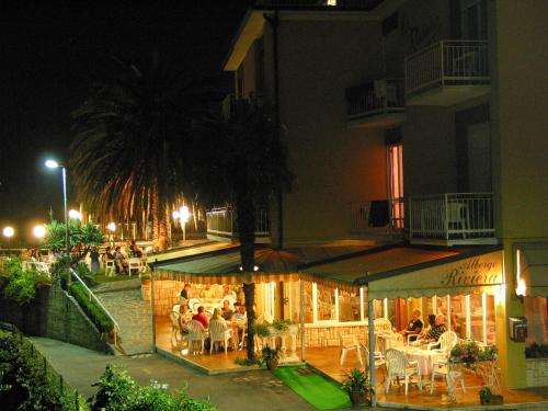 a group of people sitting at a restaurant at night at Hotel Riviera Panoramic Green Resort in Limone sul Garda