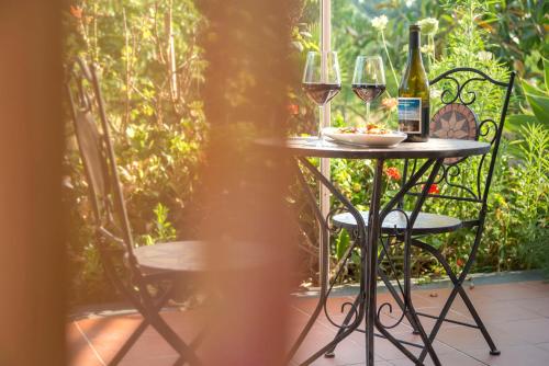 a table with two glasses of wine and a plate of food at Sicily Country House & Beach in Catania
