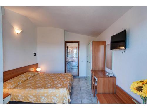 a hotel room with a bed and a television at Hotel Pedra Niedda in Budoni