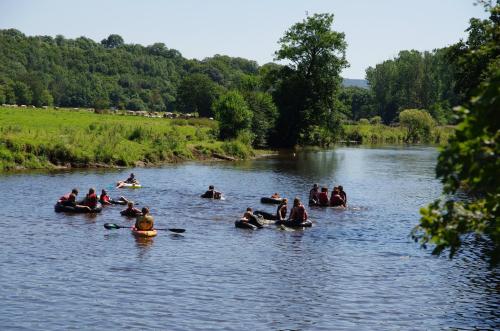 a group of people are rafting on a river at La Fleur et Le Soleil (F&S) in Durbuy