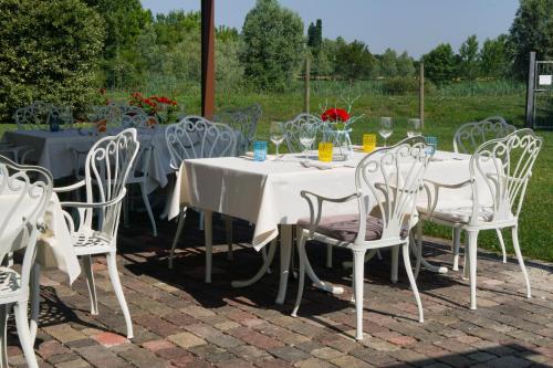 a white table and chairs with wine glasses on it at Borgo Cà dei Sospiri in Quarto dʼAltino