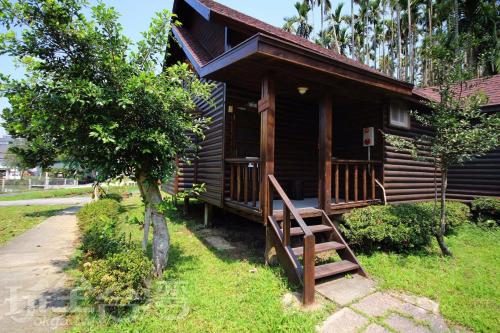 a wooden cabin with a staircase in front of it at Double Lake B&B in Zhushan