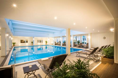 una piscina en una casa con sillas y mesa en Villa Abbazia - Liburnia en Opatija