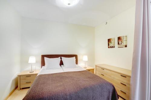 1 dormitorio con 1 cama con 2 mesitas de noche y 2 lámparas en Apartment24 - Foorum, en Tallin