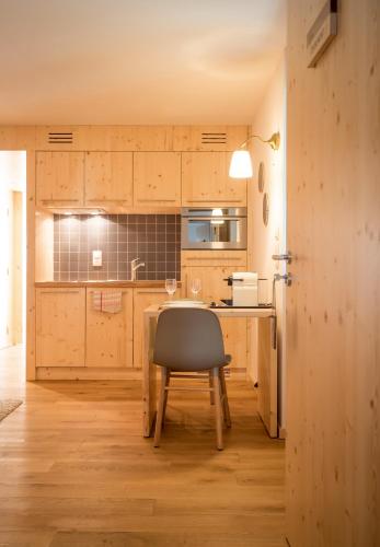 une cuisine avec une table et une chaise dans l'établissement La ferme des Colieuvres, à Lièpvre