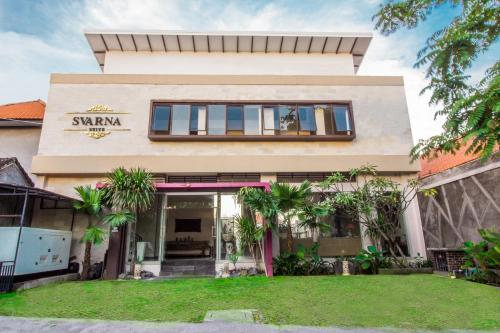 a house with a sign that reads swami at Svarna Suites Seminyak in Seminyak