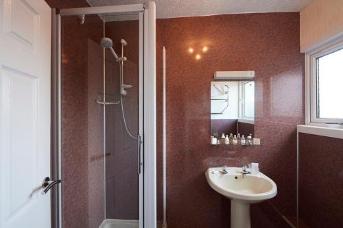 a bathroom with a sink, mirror, and bathtub at Loch Ness Clansman Hotel in Drumnadrochit