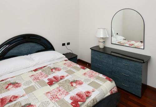 a bedroom with a bed and a dresser and a mirror at Round Venice in Marghera