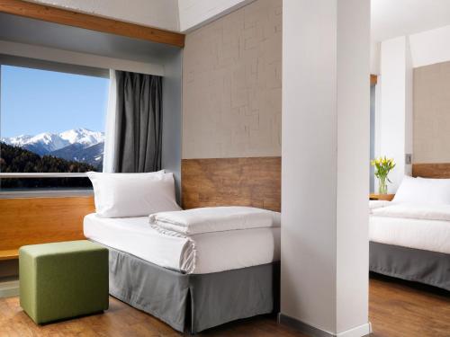 a bedroom with two beds and a window with mountains at TH Marilleva in Mezzana