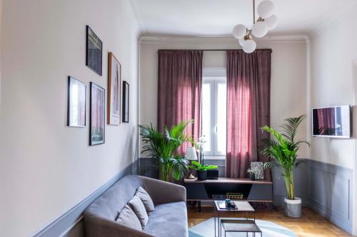 Live Life Acropolis في أثينا: غرفة معيشة مع أريكة والنباتات الفخارية