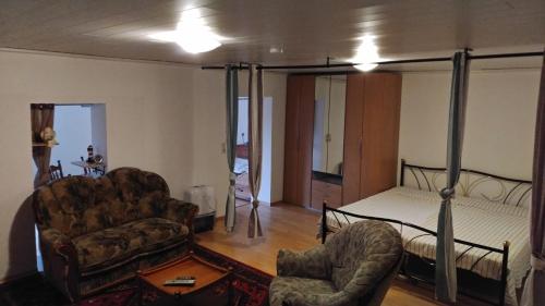 a living room with a bed and a couch and chairs at Fewo Bendig in Neuendorf-Sachsenbande