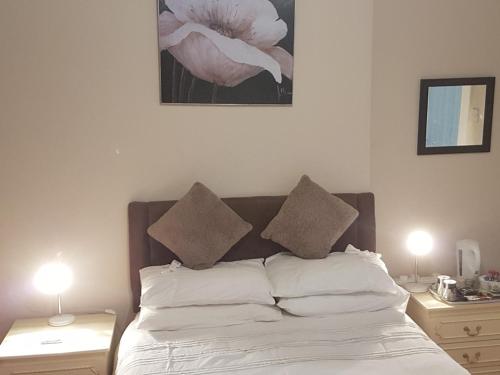 a bedroom with a bed with two tables and two lamps at The Gateway at Hest Bank in Lancaster