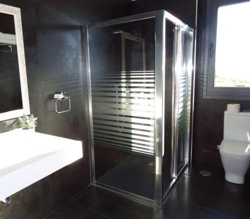 a bathroom with a shower and a sink and a toilet at Albergue Restaurante Casa Herminia in El Campiello