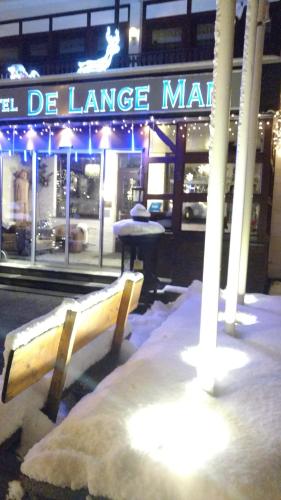 a bench in front of a store in the snow at Hotel De Lange Man Monschau Eifel in Monschau