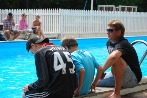 Un grupo de personas sentadas alrededor de una piscina. en Topcamp Bie - Grimstad, en Grimstad