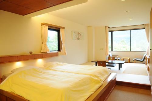 a bedroom with a large bed and a dining room at Lalaca in Hakone