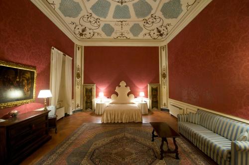 a bedroom with a bed and a couch in a room at Palazzo Tucci Residenza d'epoca in Lucca