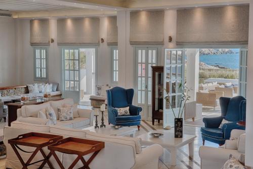 a living room with white furniture and blue chairs at San Marco Hotel and Villas in Houlakia