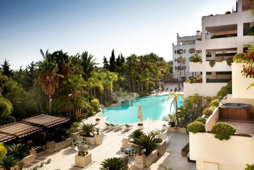 a beach scene with a pool and a large building at Apartamentos Guadalpin Boutique in Marbella
