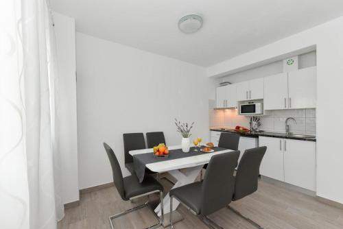 a kitchen and dining room with a table and chairs at Crowonder Luxury Vir- 6 New Apartments for Families with Playground for Kids in Vir