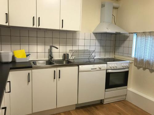 a kitchen with white cabinets and a sink at Apartments Ålholmvej in Copenhagen