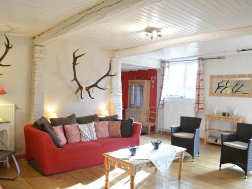 a living room with a red couch and a table at Charming holiday home in the Ardennes in Laneuville au bois in Tenneville