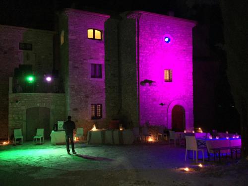 a man standing in front of a building with pink lights at B&B Il Casone di Drusa in San Marco dei Cavoti