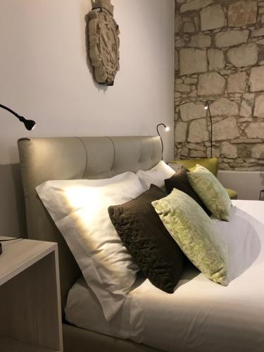 a bed with a white comforter and pillows on it at I Santi Coronati in Syracuse