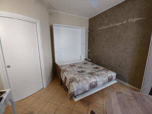 a small bedroom with a bed and a door at La Finestra Sul Lago in Cernobbio