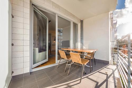 a balcony with a wooden table and chairs at Casa Marina, Sun & Snow in Świnoujście