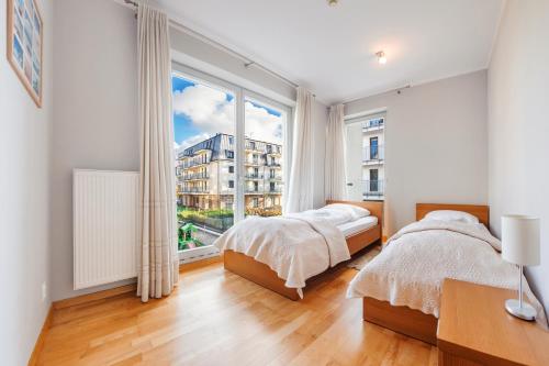 a bedroom with two beds and a large window at Casa Marina, Sun & Snow in Świnoujście