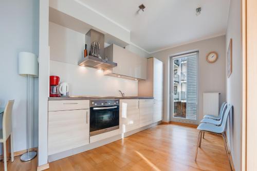 a kitchen with white cabinets and a stove top oven at Casa Marina, Sun & Snow in Świnoujście