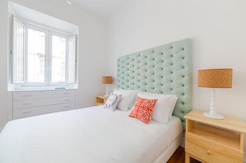 a bedroom with a white bed with a green headboard at Lisbon heart 1-cozy Flat-Family Friendly in Lisbon