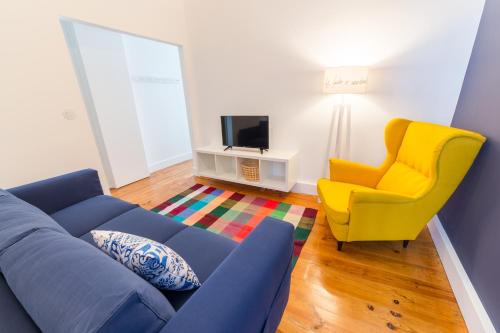 a living room with a blue couch and a yellow chair at Lisbon heart 1-cozy Flat-Family Friendly in Lisbon