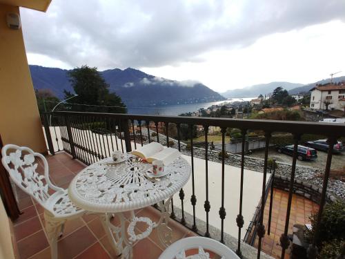 a white table and chairs on a balcony with a view at La Finestra Sul Lago in Cernobbio