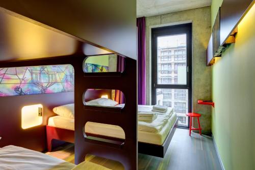 a bedroom with two bunk beds and a window at MEININGER Hotel Berlin East Side Gallery in Berlin