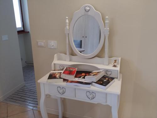 a dressing table with a mirror and books on it at La Finestra Sul Lago in Cernobbio