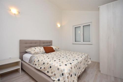 a white bedroom with a bed and a window at Ljiljana in Srima