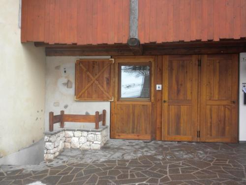 uma porta de madeira e um banco em frente a um edifício em Casa Litegosa em Panchia