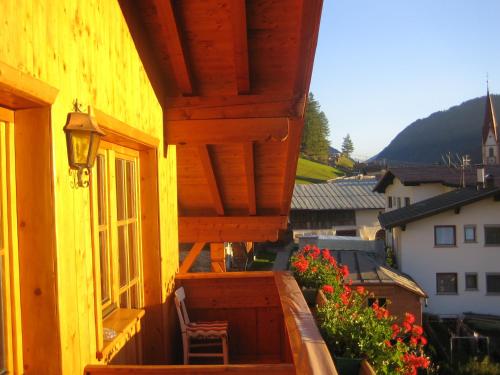 a yellow building with a chair on a balcony at Haus Brigitte in Nauders