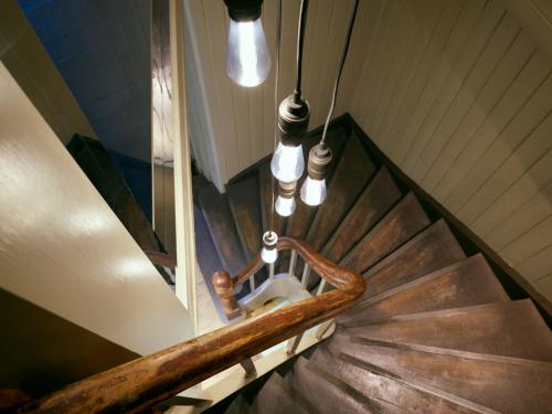 a set of stairs with a wooden rail and lights at Tollboden Hotell - Unike Hoteller in Kragerø