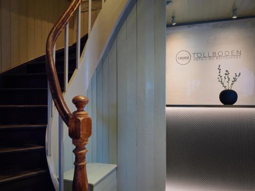 a stairwell with a staircase with a vase on the wall at Tollboden Hotell - Unike Hoteller in Kragerø