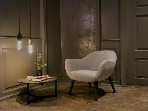 a white chair and a table in a room at Tollboden Hotell - Unike Hoteller in Kragerø
