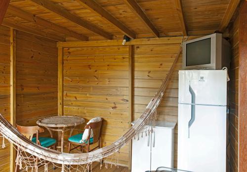 um quarto com um frigorífico, uma mesa e cadeiras em Pousada Moradas do Moçambique em Florianópolis