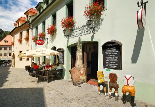a building with people sitting at a table outside at Hotel Zlaty Andel in Český Krumlov